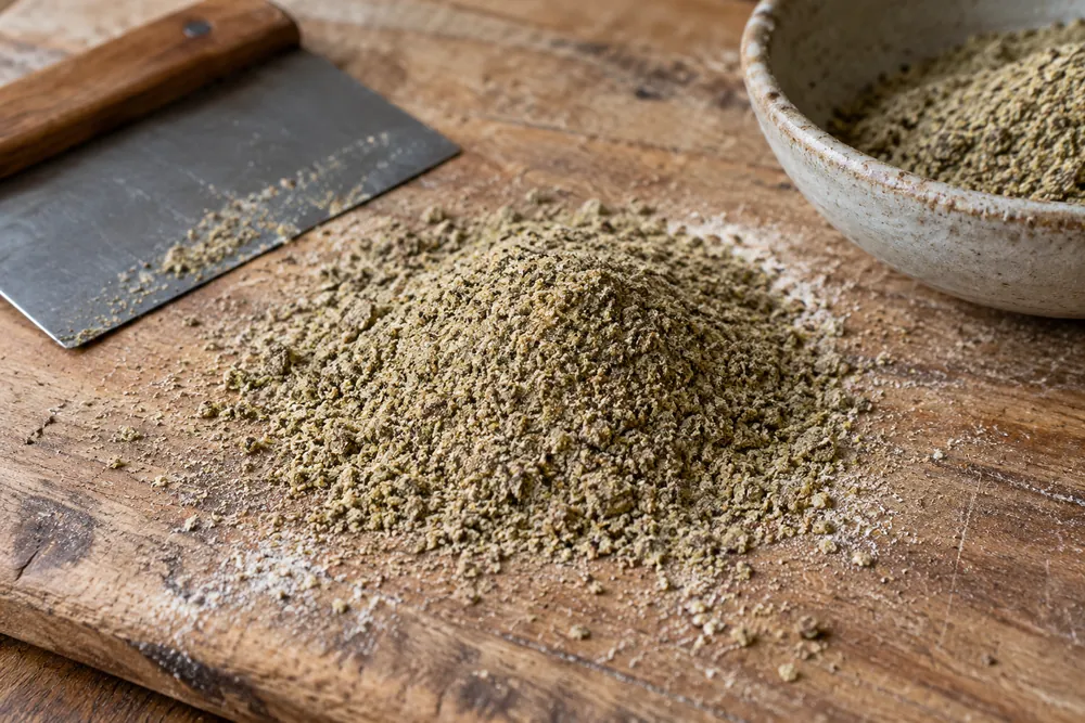 Harina de semillas de cáñamo sobre una tabla de cocina.